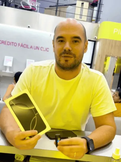 Cliente con la caja de su iPhone nuevo en la tienda