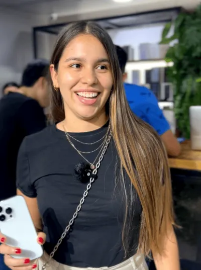 Clienta sonriendo con su iPhone blanco